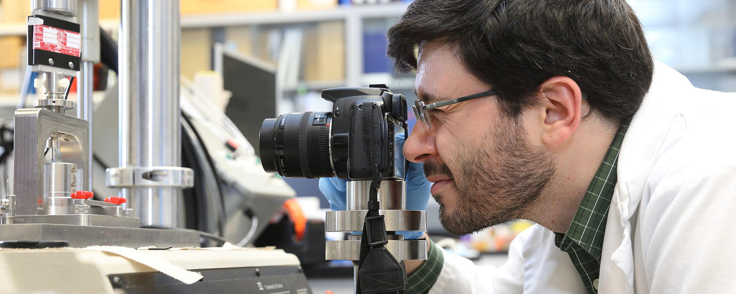 Student looking through a camera in the lab 
