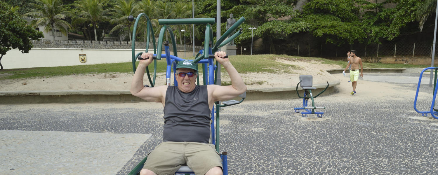 Image of Dr. MacIntosh using public exercise equipment on beach at Copa Cabana, Rio.