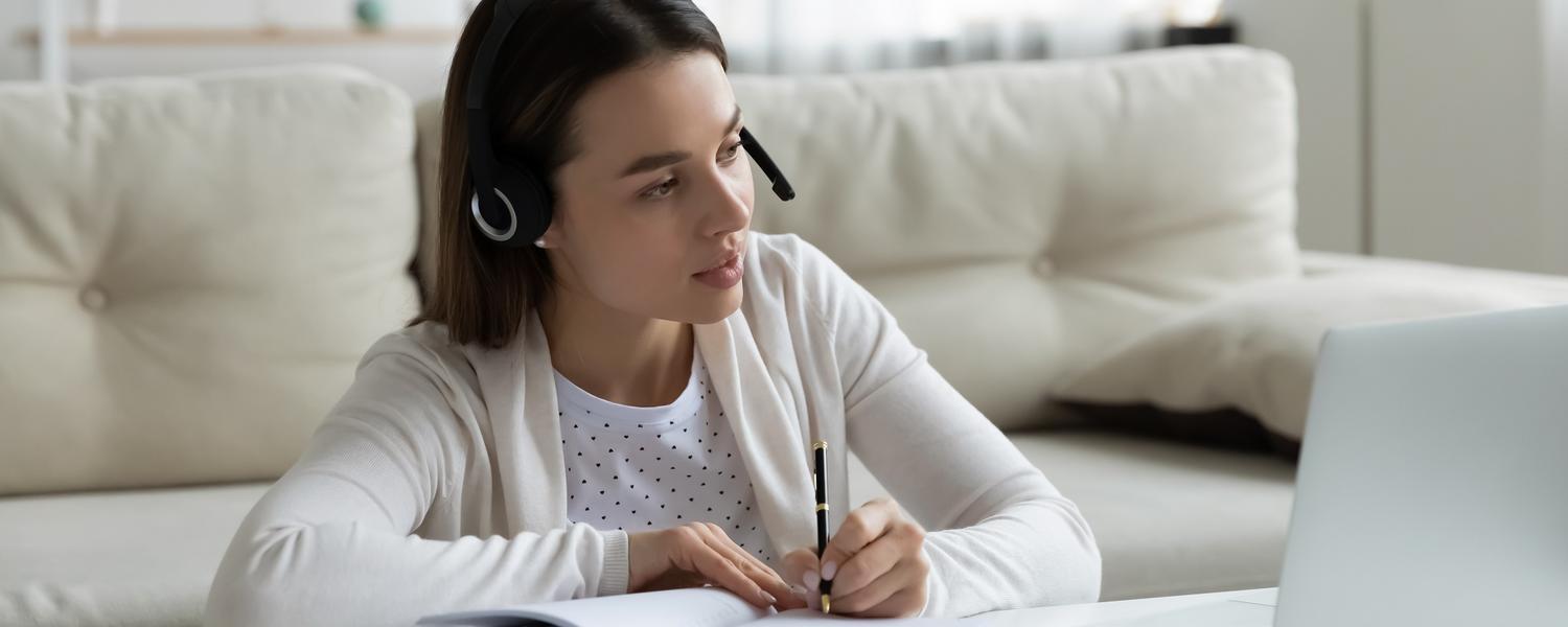 young women sitting at laptop with her book open