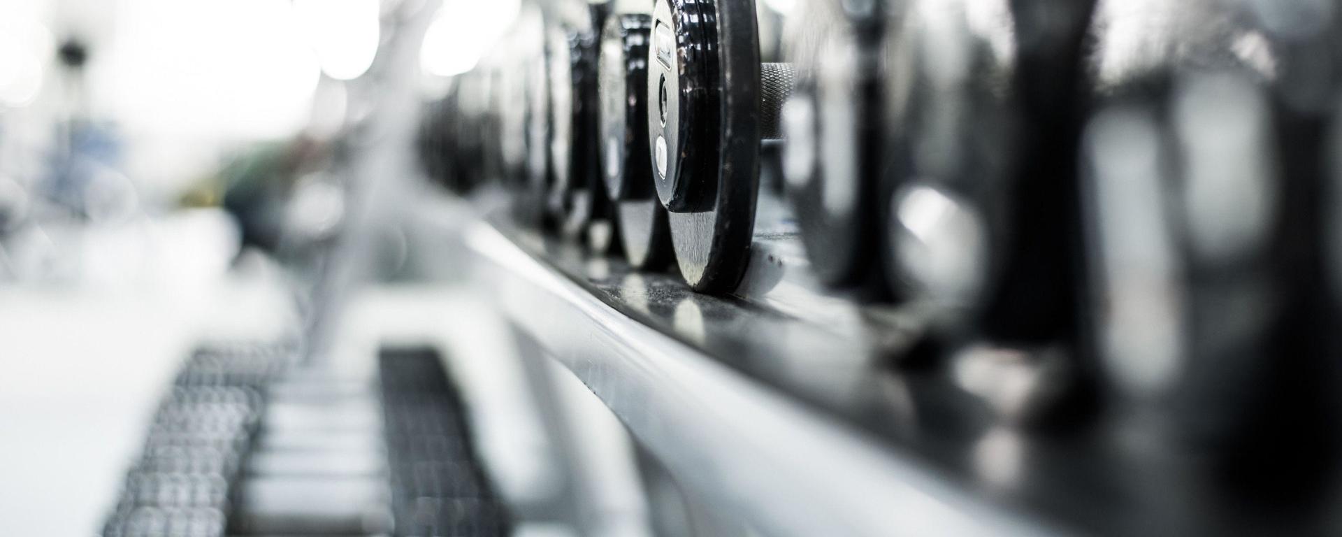 Dumbbells on a rack with white radiant light coming from behind