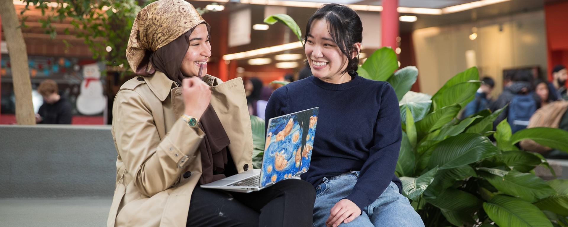 Two students chatting in the atrium