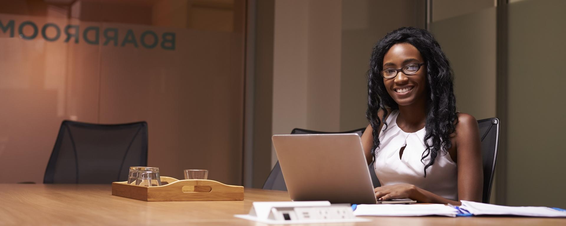 Young woman setting at boardroom table 