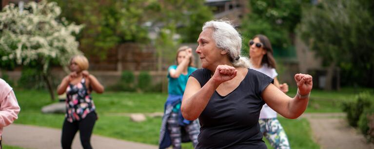 older women dancing in a class outside on a track