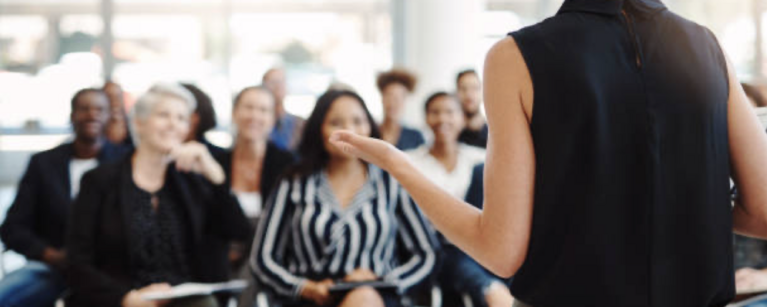 woman speaking to crowd (source iStock)
