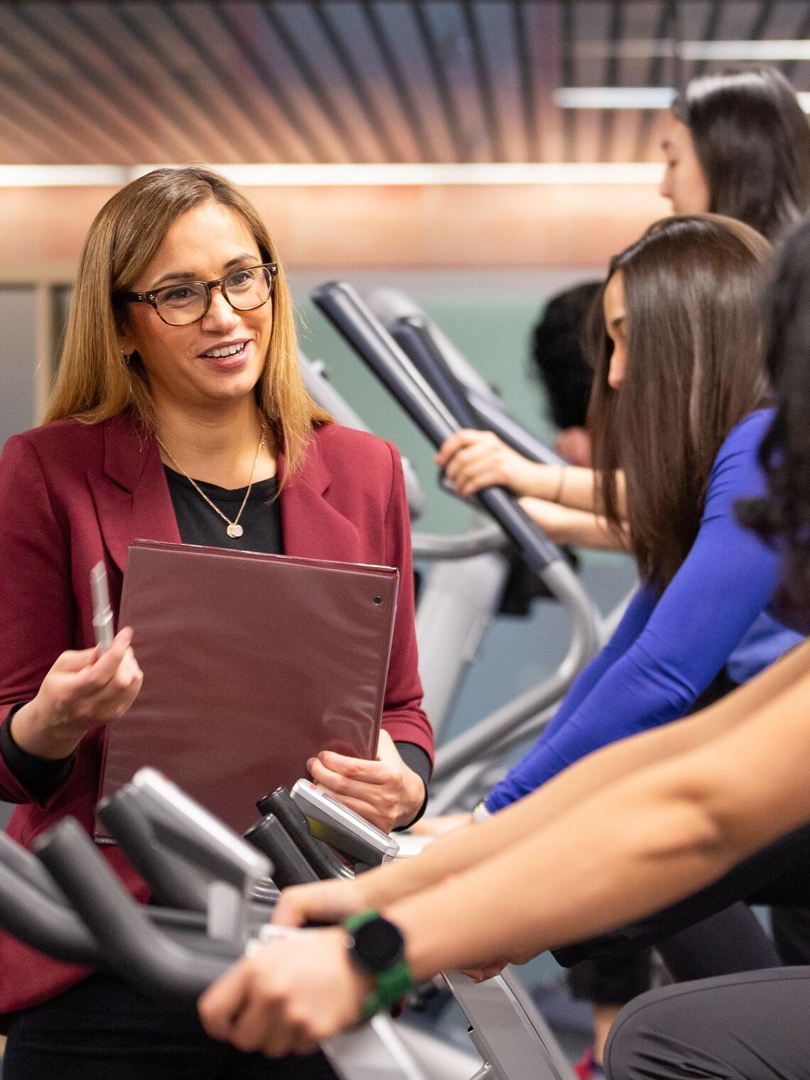 Cindy Barha talking to research participants on exercise bikes