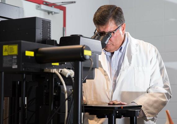 Ziad Abusara looking in microscope in HPL