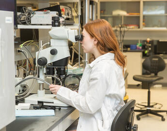 a student looking at microscope